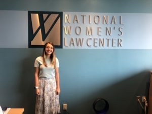 Sloan Nickel stands in front of a sign for the National Women's Law Center where she is completing an internship this summer.