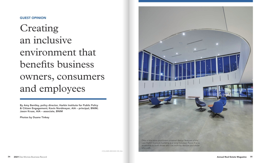 Facing pages of a magazine. The page on the left has text that reads: Guest Opinion: Creating an inclusive environment that benefits business owners, consumers and employees. By Amy Bentley, policy director, Harkin Institute for Public Policy & Citizen Engagement; Kevin Nordmeyer, AIA-Principal, BNIM; Jason Kruise, AIA-associate, BNIM. The page on the left features a large photo of The Tom and Ruth Harkin Center's atrium. The large two-story space has floor-to-ceiling windows, which show are dark blue night sky outside. A two-story ramp runs along the walls of the building. Blue chairs and wooden coffee tables are spread throughout the space.